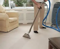 Carpet cleaning professional removing dirt and stains with a hot-water extraction tool in a home, Hollywood, FL.