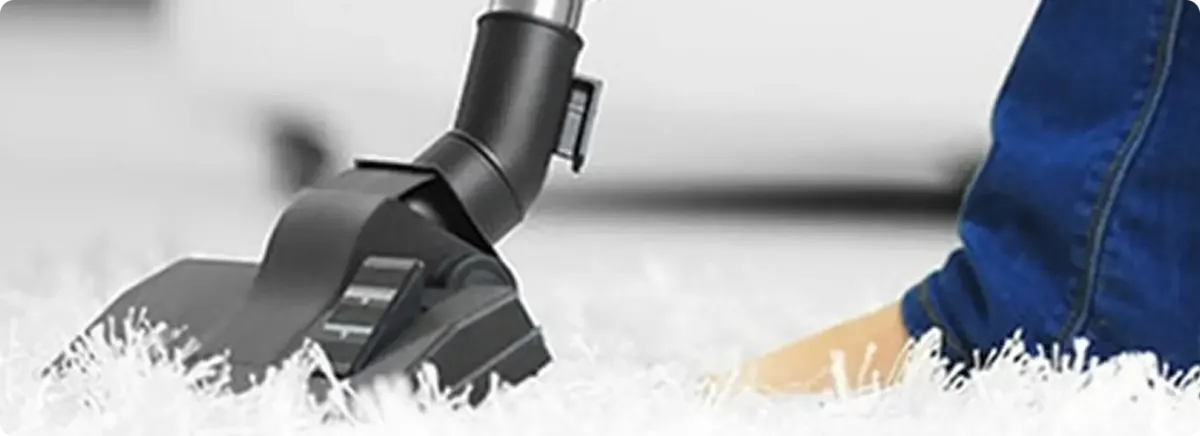 Close-up of a professional vacuuming a white carpet in Plantation.